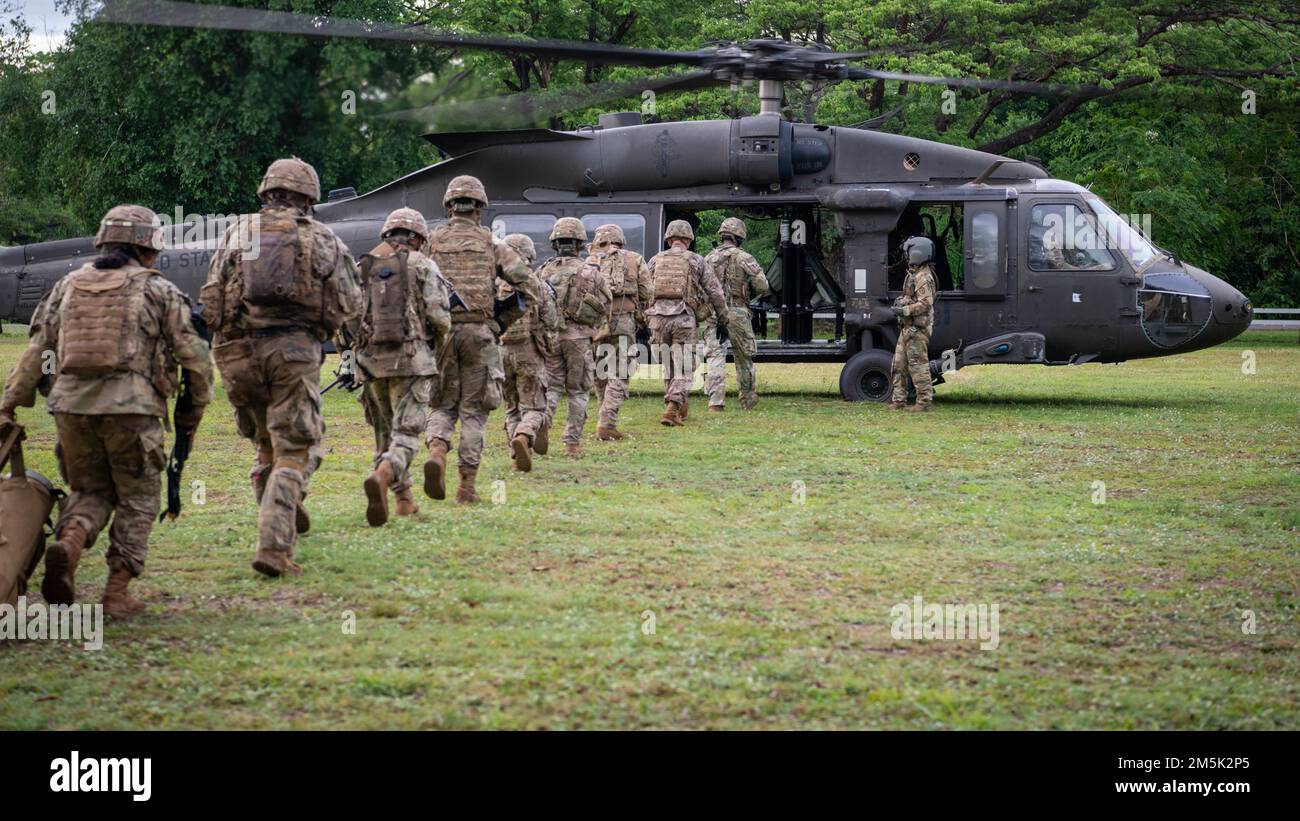 Soldiers from Alpha Company, 29th Brigade Engineer Battalion, 3rd Brigade Combat Team, 25th Infantry Division, board a U.S. Army UH-60 Black Hawk, assigned to the 2nd Assault Helicopter Battalion, 25th Aviation Regiment, 25th Infantry Division, for an air assault, Mar. 22, 2022, Fort Thanarat, Thailand. Air assaults allow troops to rapidly insert near an objective and utilize the element of surprise during the attack. Stock Photo