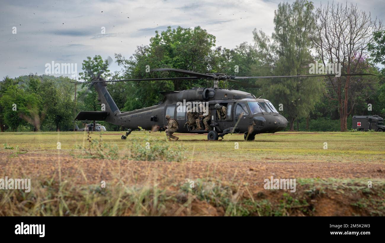 Soldiers from Alpha Company, 29th Brigade Engineer Battalion, 3rd Brigade Combat Team, 25th Infantry Division, exit a U.S. Army UH-60 Black Hawk, assigned to the 2nd Assault Helicopter Battalion, 25th Aviation Regiment, 25th Infantry Division, during an air assault, Mar. 22, 2022, Fort Thanarat, Thailand. Air assaults allow troops to rapidly insert near an objective and utilize the element of surprise during the attack. Stock Photo