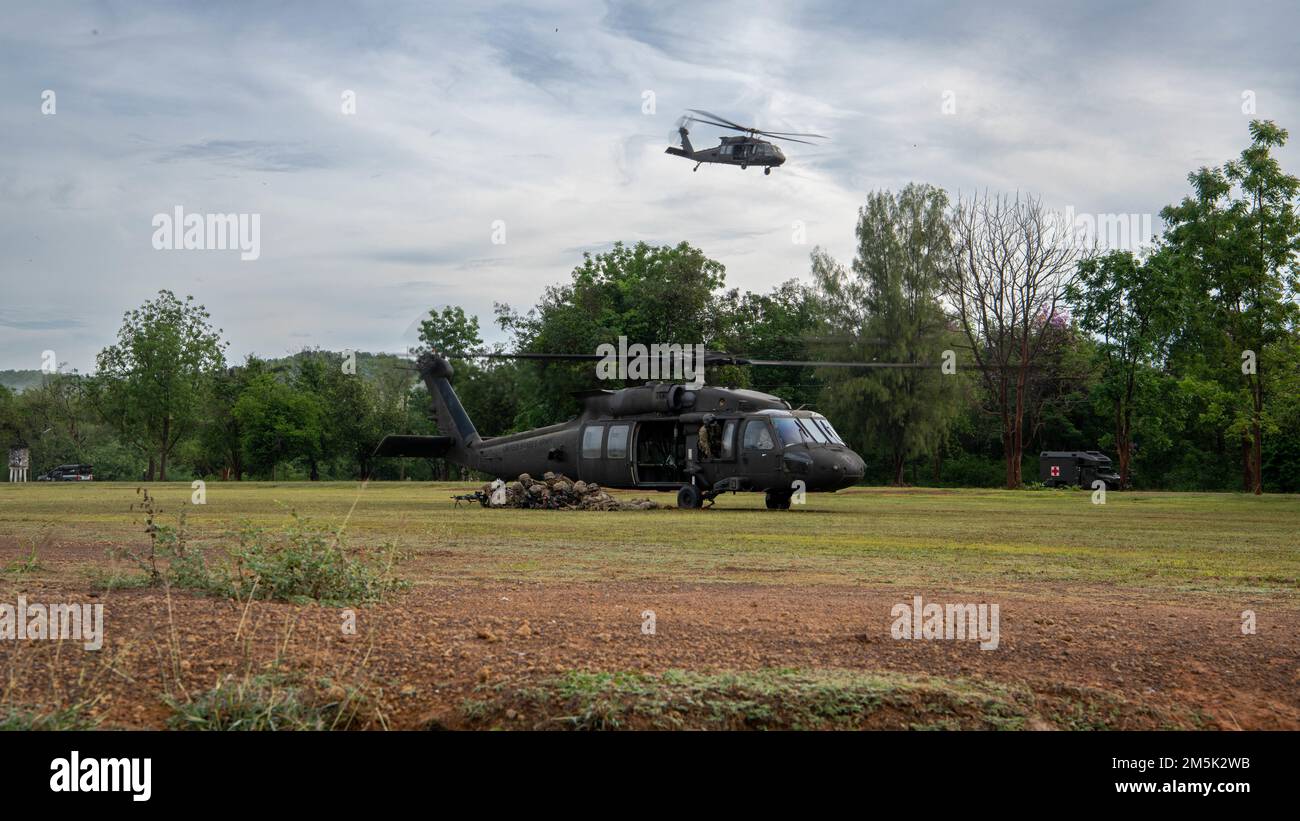 Two U.S. Army UH-60 Black Hawks, assigned to the 2nd Assault Helicopter Battalion, 25th Aviation Regiment, 25th Infantry Division, take-off during an air assault, Mar. 22, 2022, Fort Thanarat, Thailand. Air assaults allow troops to rapidly insert near an objective and utilize the element of surprise during the attack. Stock Photo