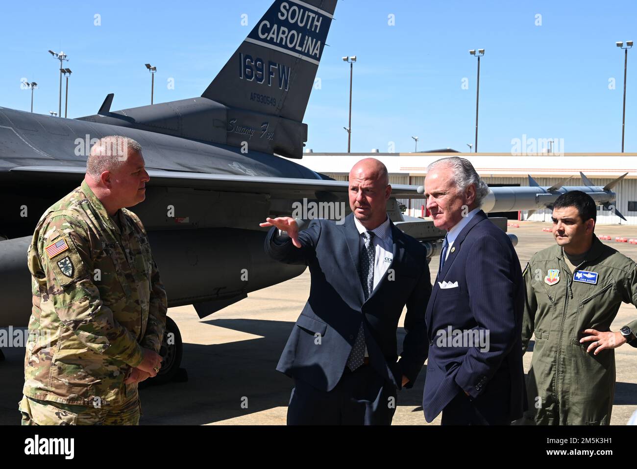 South Carolina Governor Henry McMaster, center-right, speaks with Mike Gula, center-left, Executive Director at Columbia Metropolitan Airport, with U.S. Army Maj. Gen. Van McCarty, left, The Adjutant General of South Carolina, and U.S. Air Force Col. Quaid Quadri, far right, 169th Fighter Wing Commander, in front of the South Carolina Air National Guard's flagship F-16 fighter jet at Columbia Metropolitan Airport, March 21, 2022. Columbia Metropolitan Airport hosts a press conference to announce a six-month temporary move of F-16 fighter jet flying operations from the the South Carolina Air Na Stock Photo