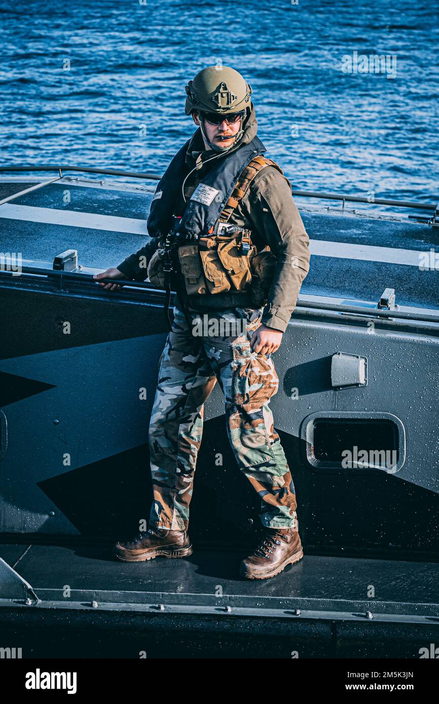 A Korps Marinier with the Royal Netherlands Marine Corps prepares to dock a Landing Craft Vehicle Personnel (LCVP) during Exercise Cold Response 22 in Sandstrand, Norway, March 21, 2022. Exercise Cold Response 22 is a biennial Norwegian national readiness and defense exercise that takes place across Norway, with participation from each of its military services, including 26 North Atlantic Treaty Organization (NATO) allied nations and regional partners. Stock Photo