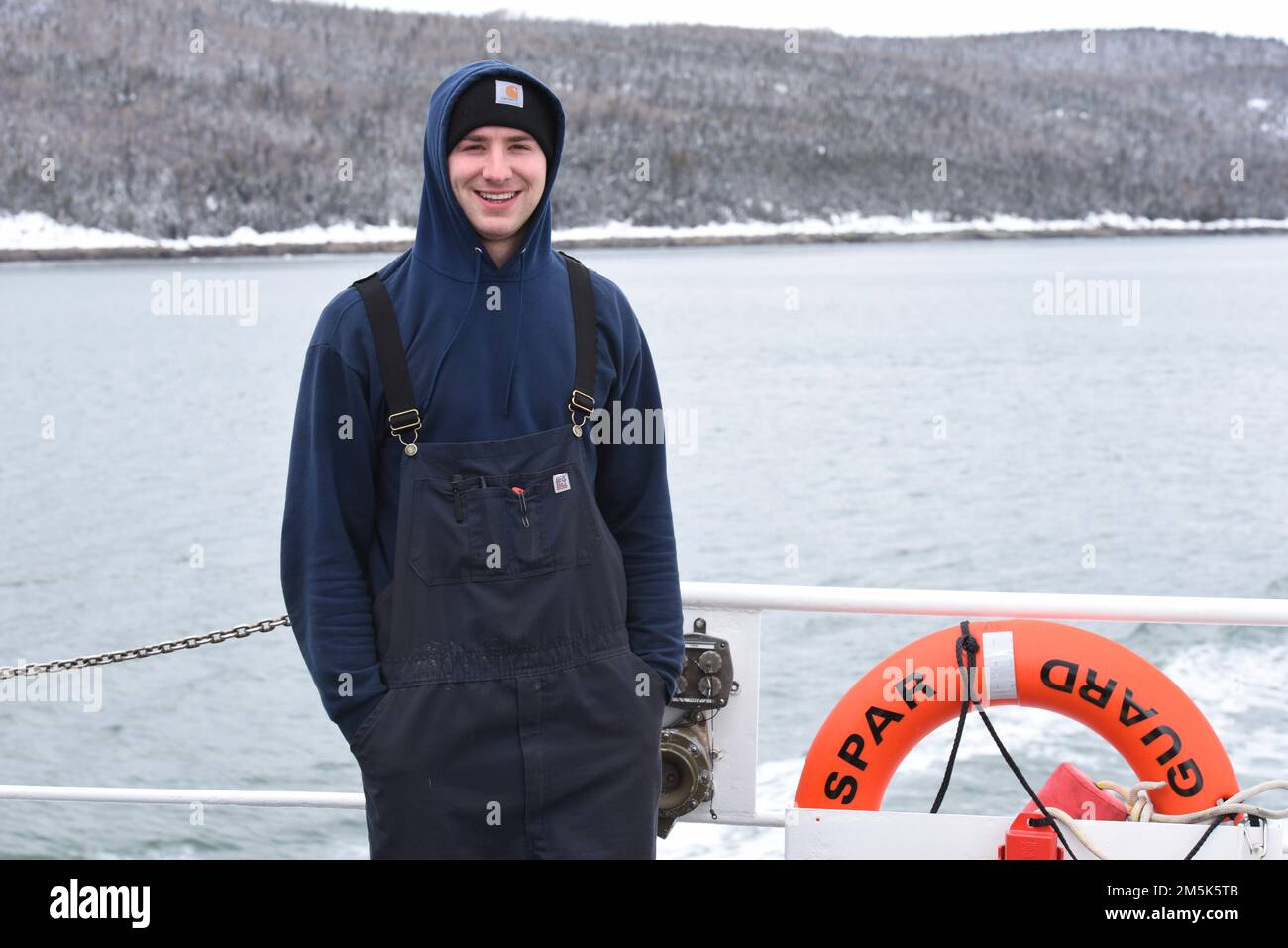 U.S. Coast Guard Petty Officer 3rd Class Michael Covey, a Machinery Technician aboard Cost Guard Cutter Spar, poses for a photo on the fantail while underway in the St. Lawrence River, March 21, 2022.Spar and her crew are traveling to Duluth, Minn. after a year-long maintenance period in Baltimore. Stock Photo