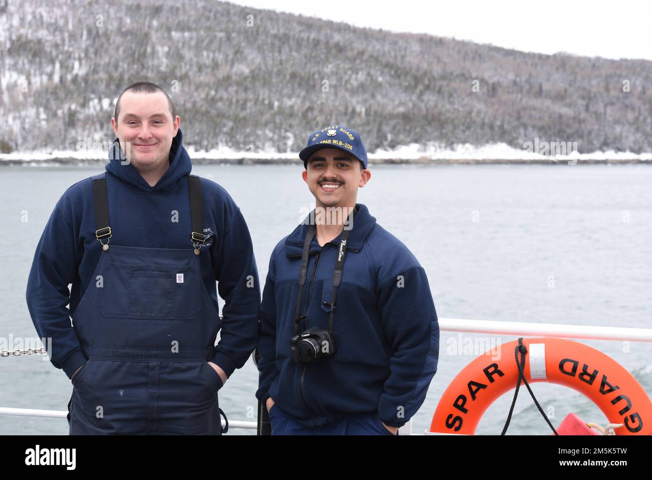U.S. Coast Guard Petty Officer 3rd Class Frank Aurelio [left] and Seaman Alexander Landry, crew members aboard Coast Guard Cutter Spar, pose for a photo on the fantail while underway in the St. Lawrence River, March 21, 2022. Spar and her crew are traveling to Duluth, Minn. after a year-long maintenance period in Baltimore. Stock Photo