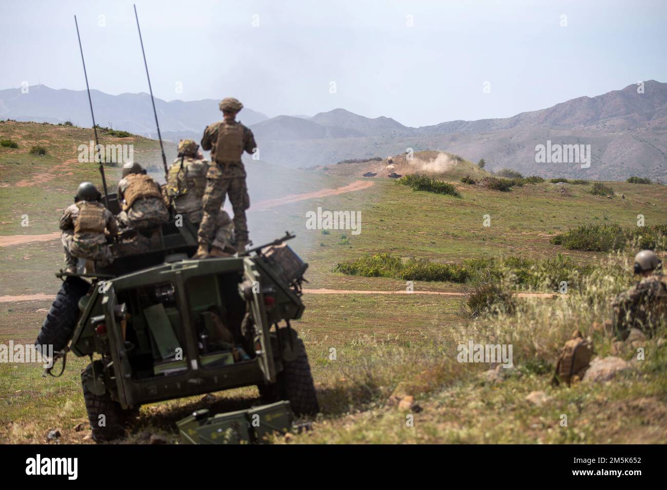 U.S. Marines with 1st Light Armored Reconnaissance Battalion, 1st Marine Division; Explosive Ordnance Disposal Detachment, Headquarters and Support Battalion, Marine Corps Base Camp Pendleton, and U.S. Army soldiers with the 184th Ordnance Battalion, 52nd Ordnance Group, fire an M242 Bushmaster 25 mm chain gun during a stand-off munitions disruption training range at Range 408 on Marine Corps Base Camp Pendleton, March 21, 2022. SMUD is a technique used by EOD technicians to quickly and effectively neutralize ordnance from a safe distance. Stock Photo