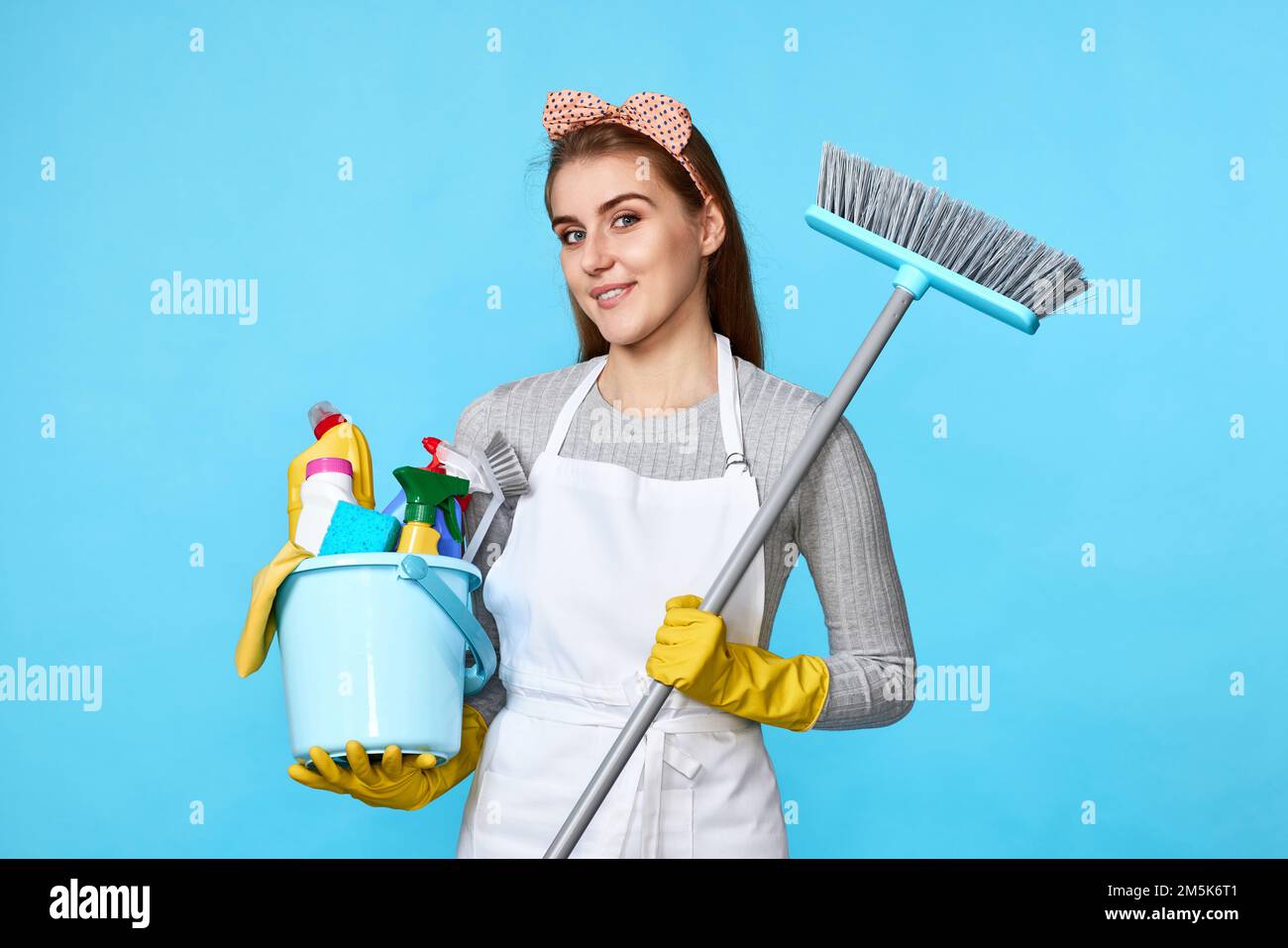 woman in gloves holding bucket of detergents and broom Stock Photo - Alamy