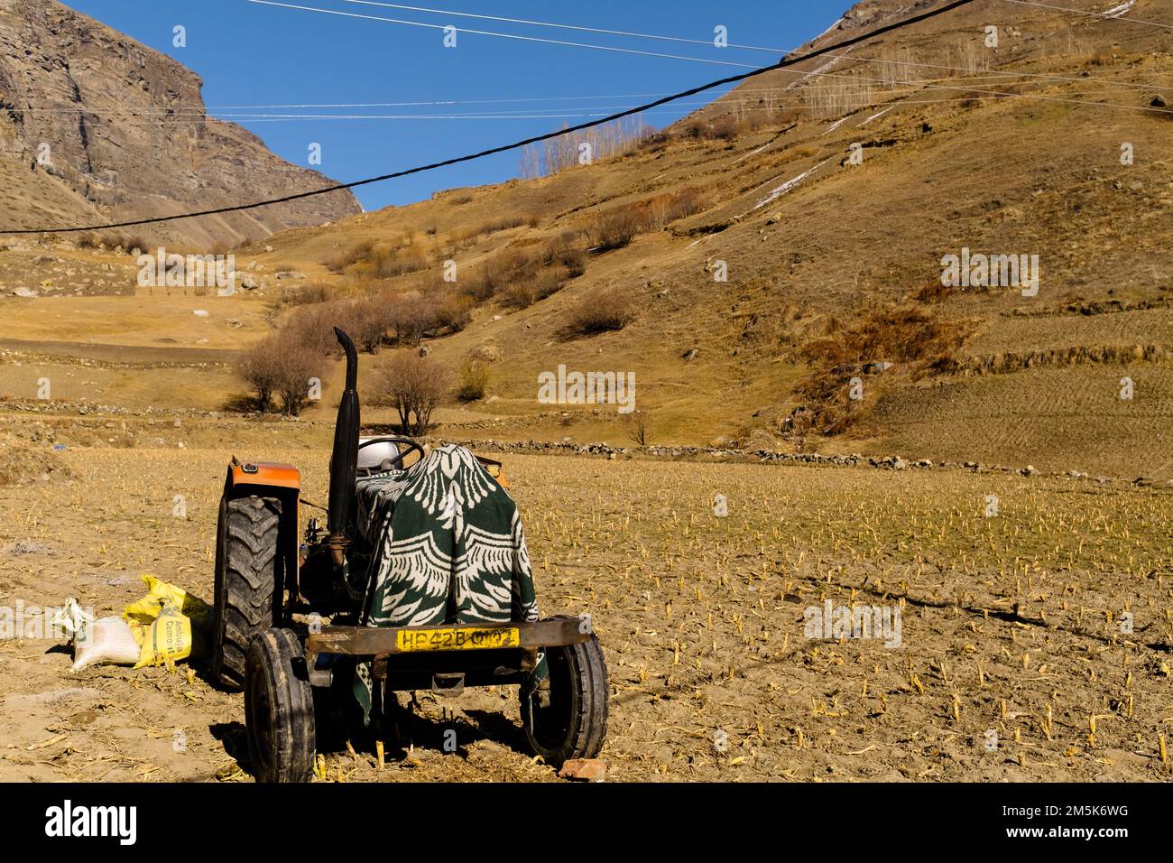 Tactor with disk harrow on ploughing field. Cultivated land and soil