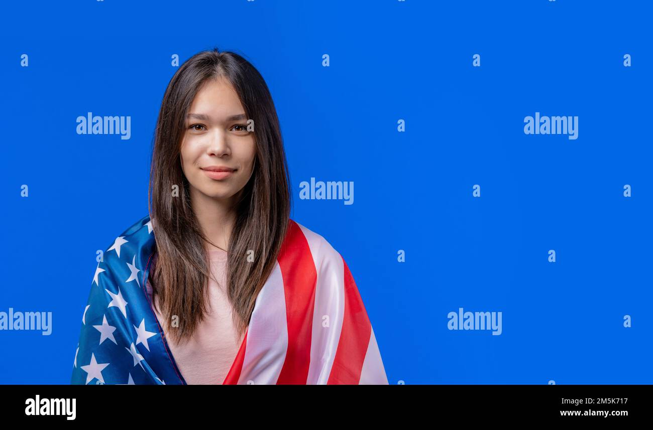 Smiling woman with national USA flag on blue background. American patriot, 4th of July - Independence day celebration, election, America, labor. US Stock Photo