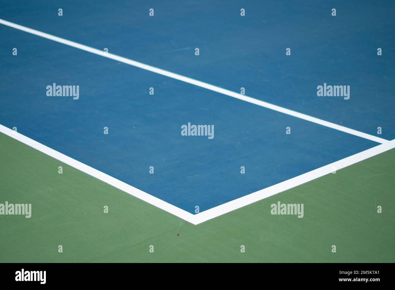 The left sideline of a blue tennis court with white lines, concept of a