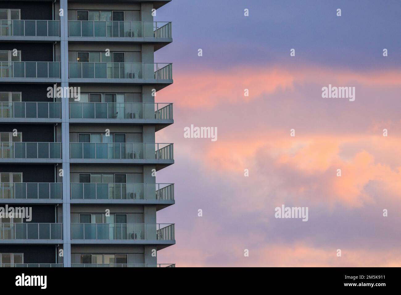 Exterior balconies on luxury apartment tower with beautiful sunset sky Stock Photo