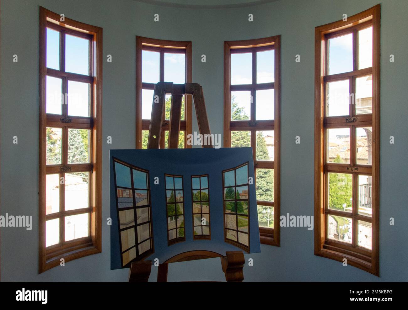 Double view. Window in a turret of the Casa de los Botines building by architect Antoni Gaudí with a painting of the same view. Stock Photo