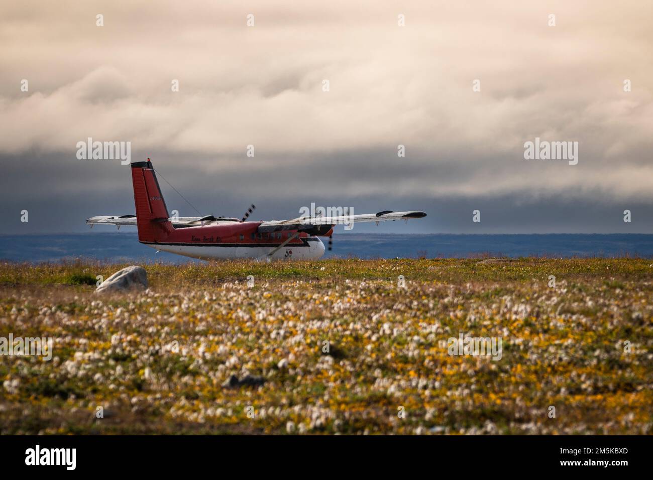 DHC6 Twin Otter of Kenn Borek Air taking off from a dirt airstrip in Pond Inlet on Baffin Island in Nunavut, Northern Canada. Stock Photo