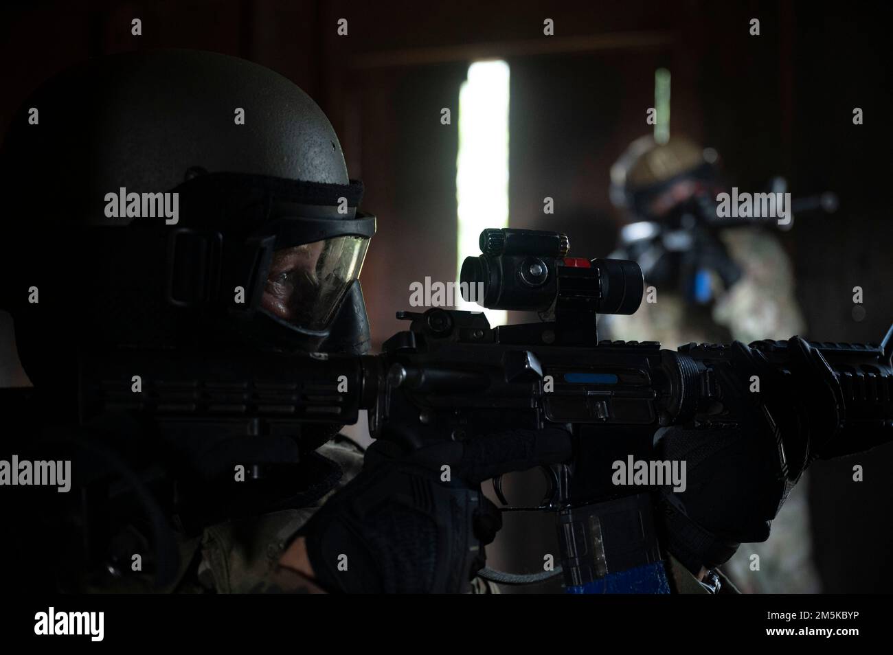 Airmen participating in urban training aim their rifles towards a window to provide security during Fieldcraft Hostile on Joint Base McGuire-Dix-Lakehurst, New Jersey, Aug. 4, 2022. FCH places students in realistic and strenuous training scenarios used to teach skills such as weapons control, combative techniques, communications, mounted and dismounted individual and team movements and land navigation. (U.S. Air Force photo by Staff Sgt. Jake Carter) Stock Photo
