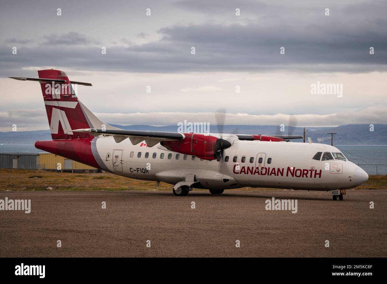 ATR 72 cargo and passenger aircraft belonging to Canadian North Airlines on the gravel airstrip at Pond Inlet, Baffin Island, Nunavut, Canada. Stock Photo