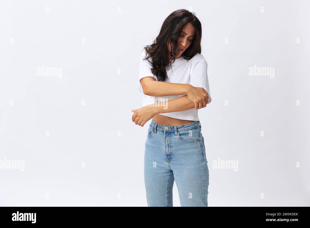 Woman pain in her arm, wrist sprain, bruised elbow in a white tshirt