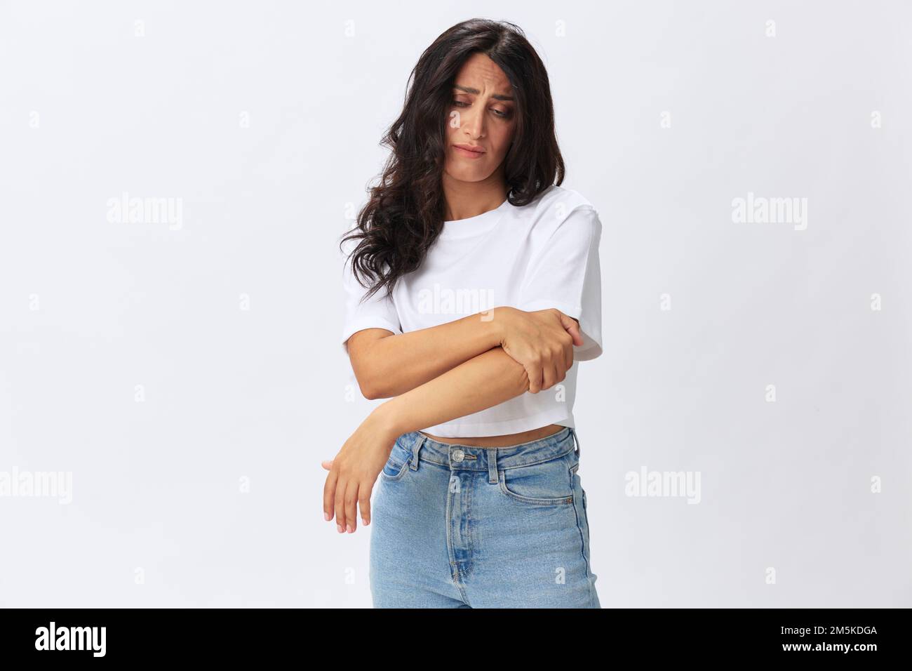 Woman pain in her arm, wrist sprain, bruised elbow in a white tshirt