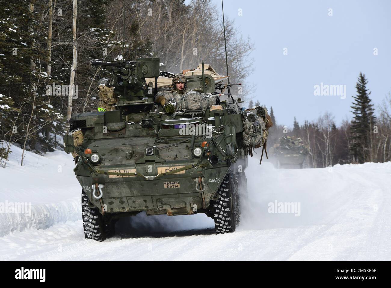 Stryker vehicles from the 3rd Battalion, 21st Infantry Regiment move down a snowy road in the Donnelly Training Area during Joint Pacific Multinational Readiness Center 22-02, March 22, 2022. This exercise is designed to validate U.S. Army Alaska’s 1st Stryker Brigade Combat Team, 25th Infantry Division’s cold weather training, readiness and capabilities.  (Army photo/John Pennell) Stock Photo