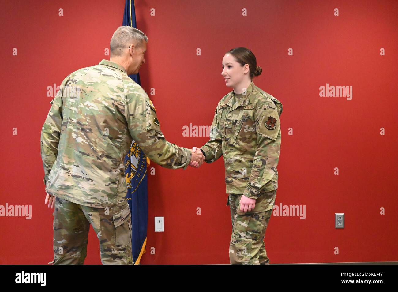 General Daniel Hokanson, Chief, National Guard Bureau, presents a coin to Senior Airman Casey Englebart, combat crew communications specialist of the 155th Operations Support Staff, on March 22, 2022, at the Lincoln air force base, Nebraksa.  Hokanson visited with senior leaders, Airmen, and Soldiers of the Nebraska National Guard. Stock Photo