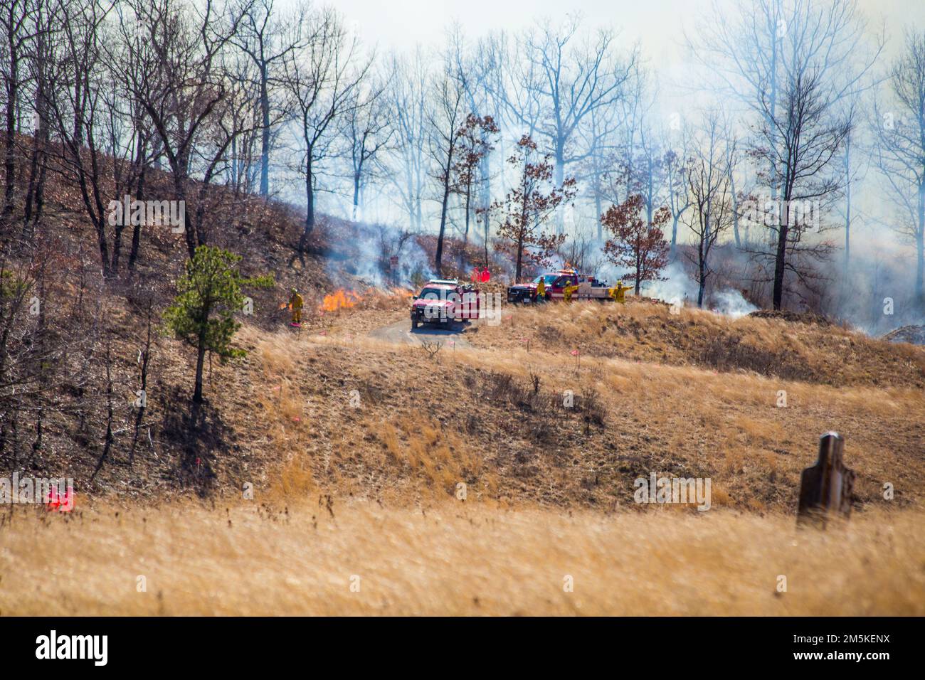 Firefighter using a blow torch to light the perimeter of the fire area on fire to start a back