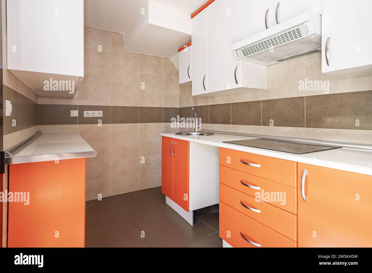 Kitchen with orange furniture in the lower part and white with a