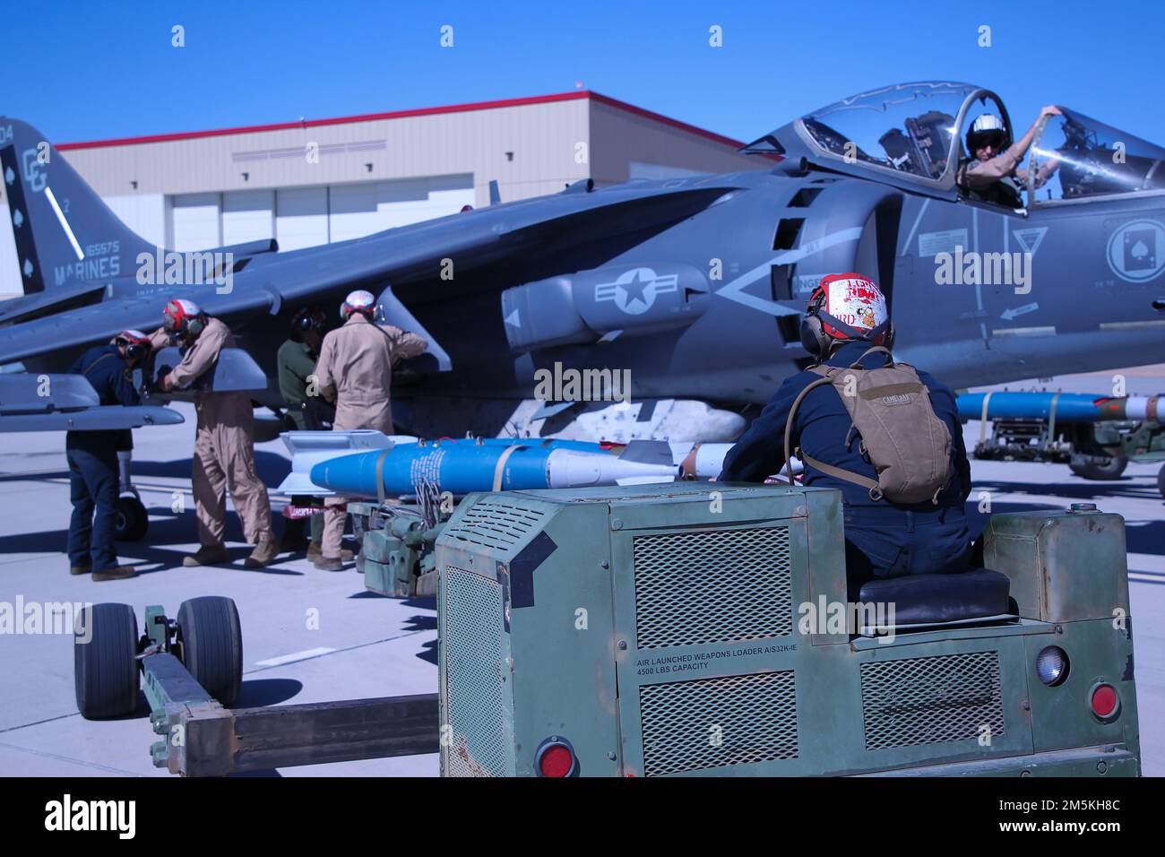 U.S. Marine Corps aviation ordnance technicians, assigned to Marine Aviation Weapons and Tactics Squadron One (MAWTS-1), load ordnance onto an AV-8B Harrier II, during Weapons and Tactics Instructor (WTI) course 2-22, at Marine Corps Air Station Yuma, Arizona, March 22, 2022. WTI is a seven-week training event hosted by MAWTS-1, providing standardized advanced tactical training and certification of unit instructor qualifications to support Marine Aviation training and readiness, and assists in developing and employing aviation weapons and tactics. Stock Photo