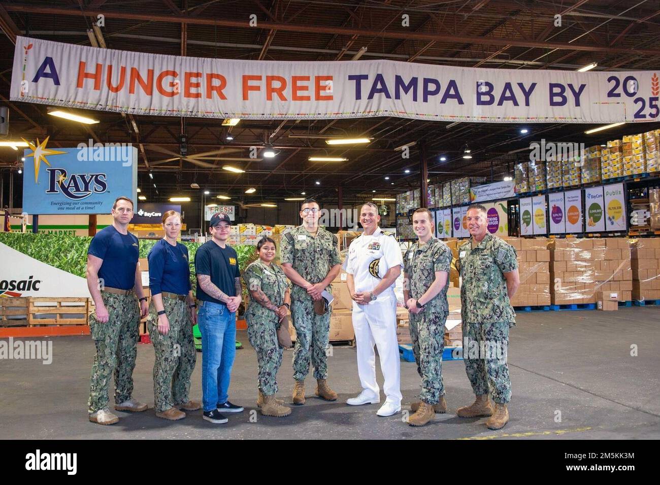 TAMPA, Fla. (March 22, 2022) The commanding officer of the Ohio-class guided-missile submarine USS Florida (SSGN 728) Blue Crew, Capt. Gabriel Anseeuw, poses with members of his crew and Explosive Ordnance Disposal Group 2 while volunteering at Feeding Tampa Bay for Tampa Navy Week 2022. Navy Week is an annual series of events held throughout the year in various U.S. cities without a significant Navy presence to provide an opportunity for citizens to interact with Sailors and learn about the Navy and its capabilities. Stock Photo
