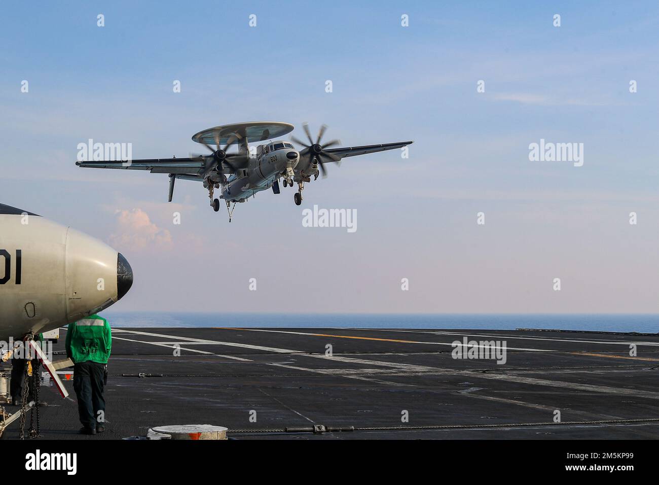 SOUTH CHINA SEA (March 23, 2022) An E-2D Hawkeye, assigned to the 'Wallbangers' of Carrier Airborne Early Warning Squadron (VAW) 117, prepares to make an arrested landing on the flight deck of the Nimitz-class aircraft carrier USS Abraham Lincoln (CVN 72). Abraham Lincoln Strike Group is on a scheduled deployment in the U.S. 7th Fleet area of operations to enhance interoperability through alliances and partnerships while serving as a ready-response force in support of a free and open Indo-Pacific region. Stock Photo
