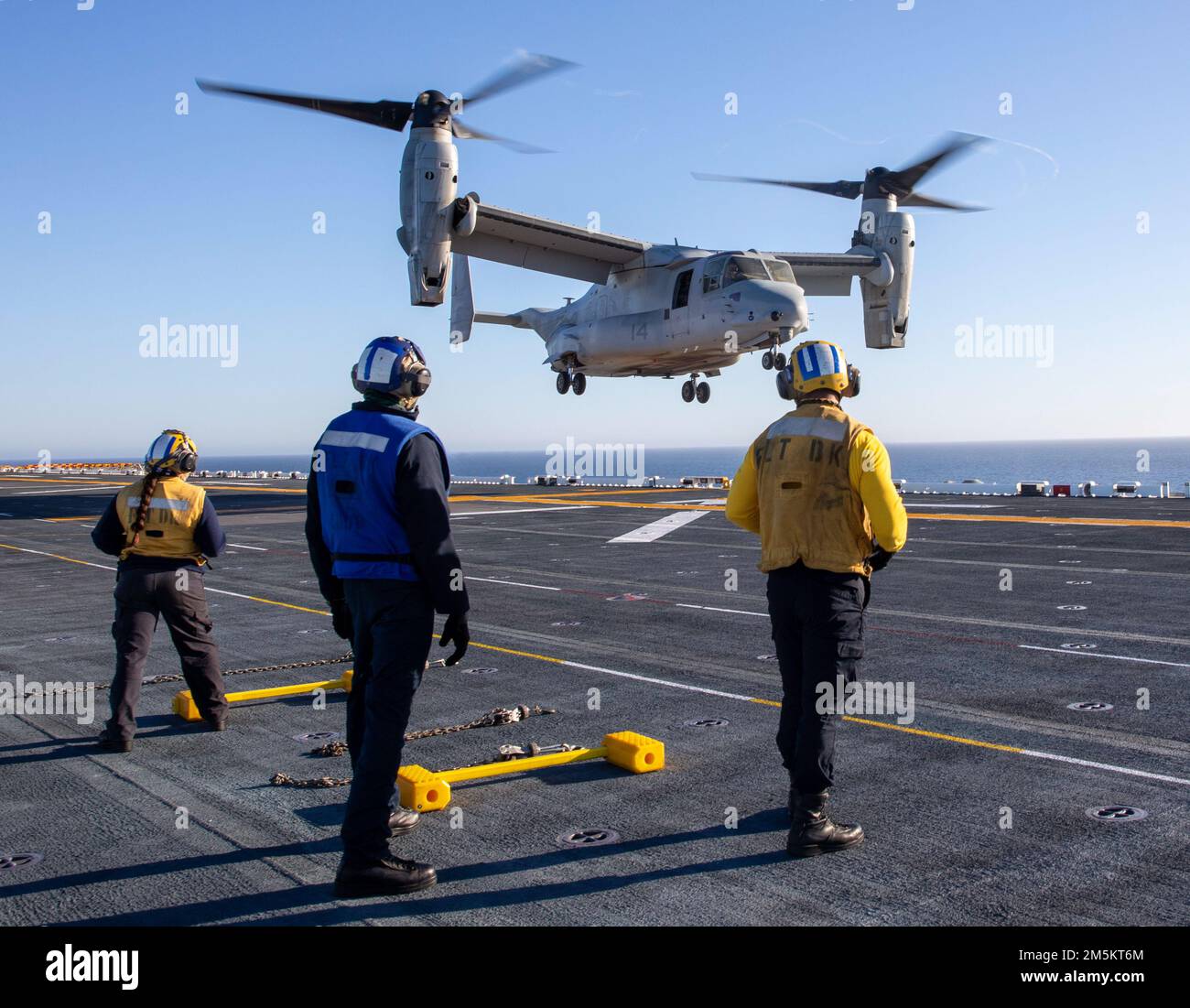 220323-N-IV962-1317    PACIFIC OCEAN (March 23, 2022) – Sailors observe an MV-22 Osprey, assigned to Marine Medium Tiltrotor Squadron (VMM) 362, landing on the flight deck of amphibious assault ship USS Makin Island (LHD 8), March 23. Makin Island is underway conducting routine operations in U.S. 3rd Fleet. Stock Photo