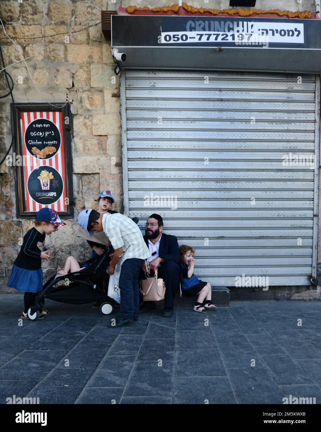 A father with his children on Jaffa street near the Mahane Yehuda market in Jerusalem, Israel. Stock Photo