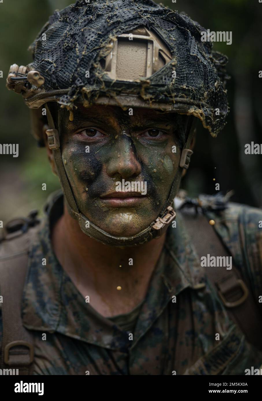 U.S. Marine Corps Staff Sgt. Charles Copeland, a joint terminal attack controller with 5th Air Naval Gunfire Liaison Company, III Marine Expeditionary Force Information Group, looks into a camera after completing an endurance course at Jungle Warfare Training Center, Camp Gonsalves, Okinawa, Japan, March 24, 2022. The endurance course was part of an overall Jungle Field Exercise conducted on March 21-25. During the FEX, III MIG Marines practiced their ability to conduct distributed operations in an austere environment. JWTC provides challenging terrain that is found on many of the islands in t Stock Photo