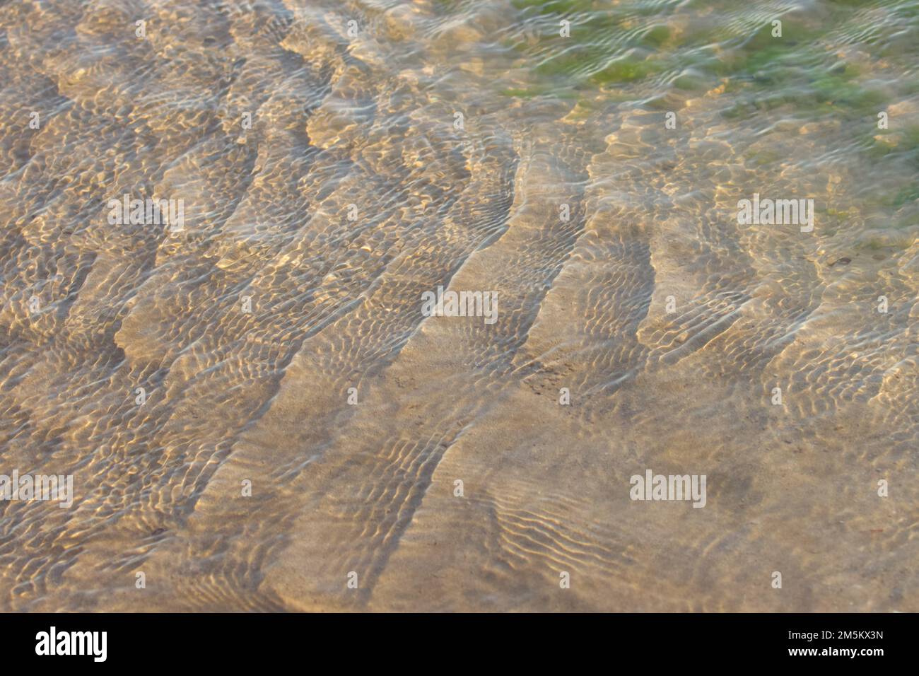 Clear, transparent, ripple ocean water over beach sand Stock Photo - Alamy