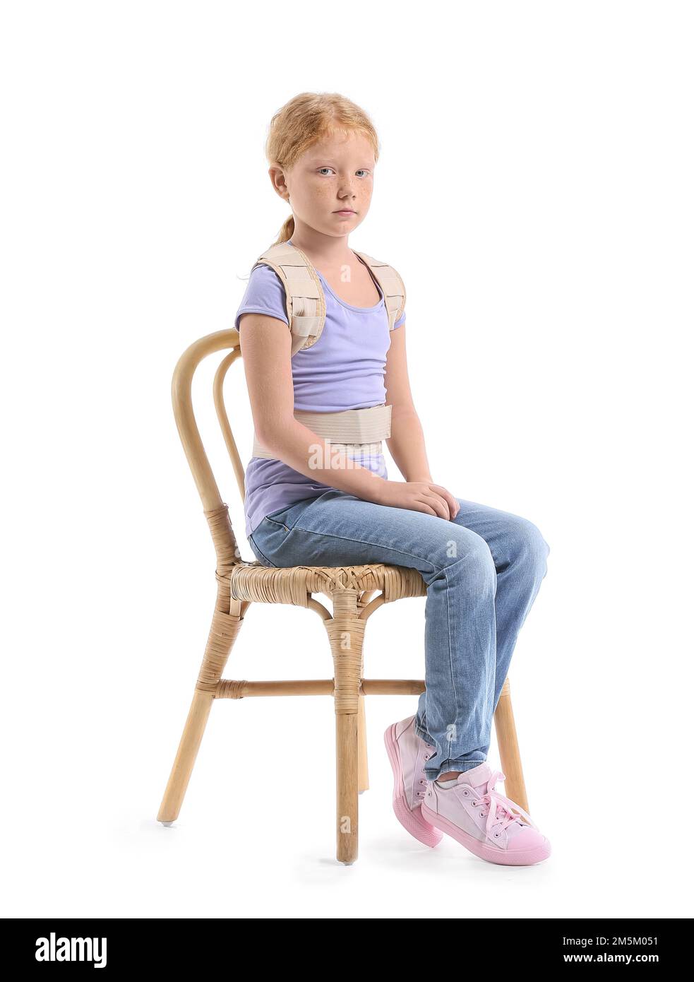 Little girl in back brace sitting on white background Stock Photo Alamy