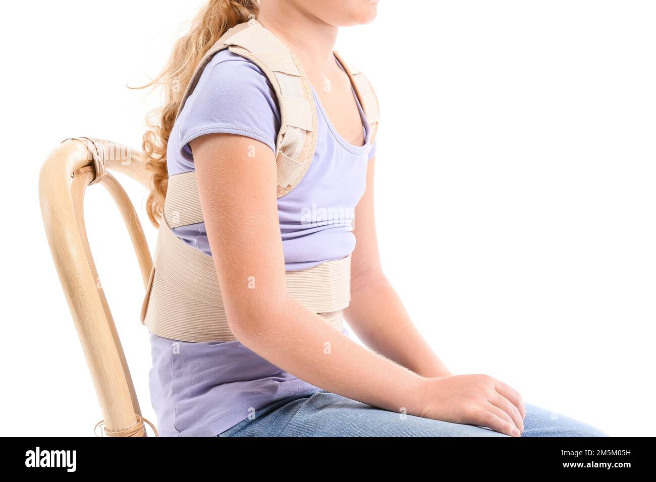 Little girl in back brace sitting on white background Stock Photo Alamy