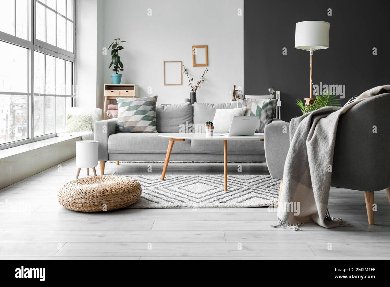 Interior of light living room with grey sofa, armchair and lamp Stock ...