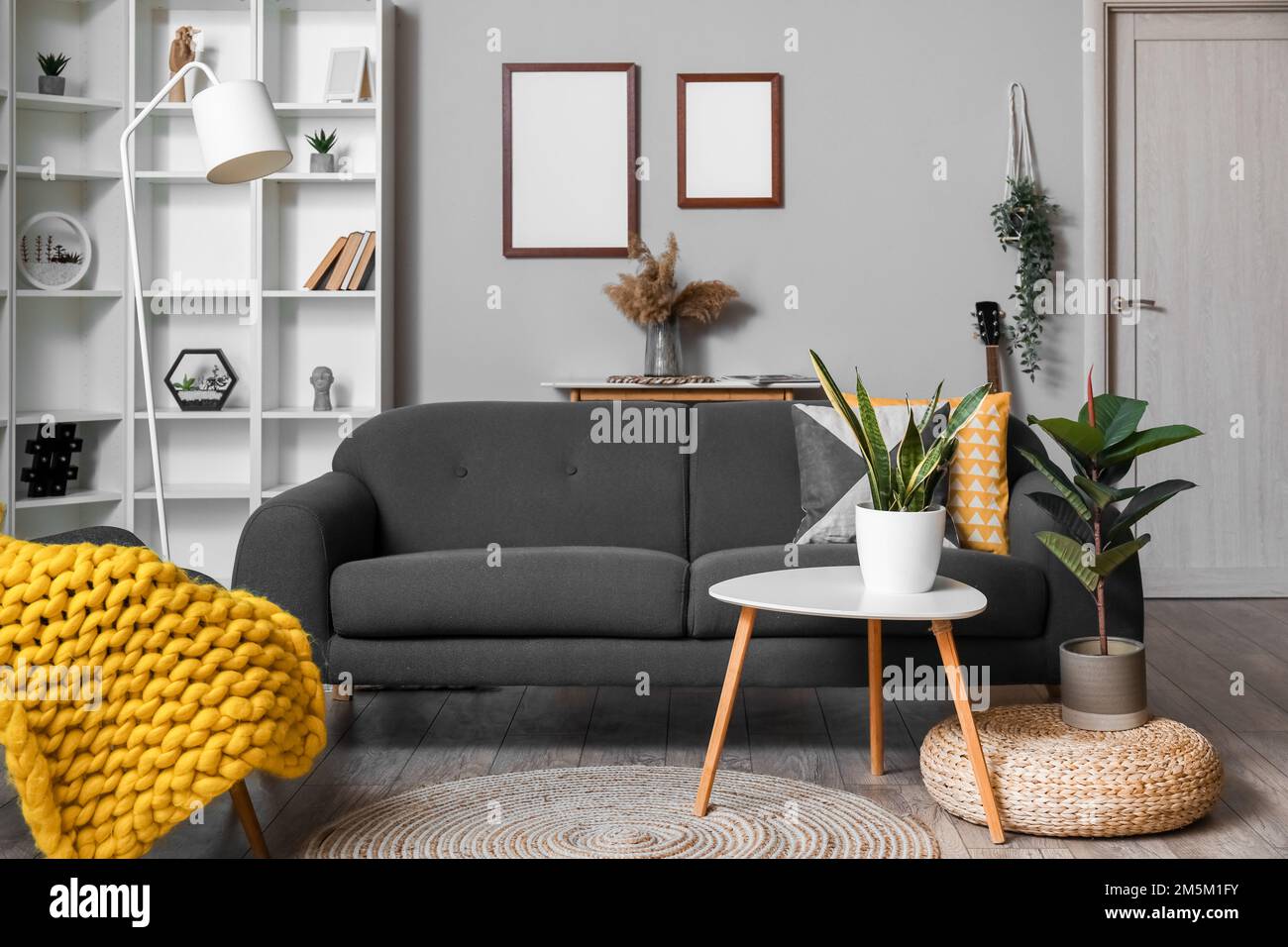 Interior of modern living room with black sofa, tables and shelving ...