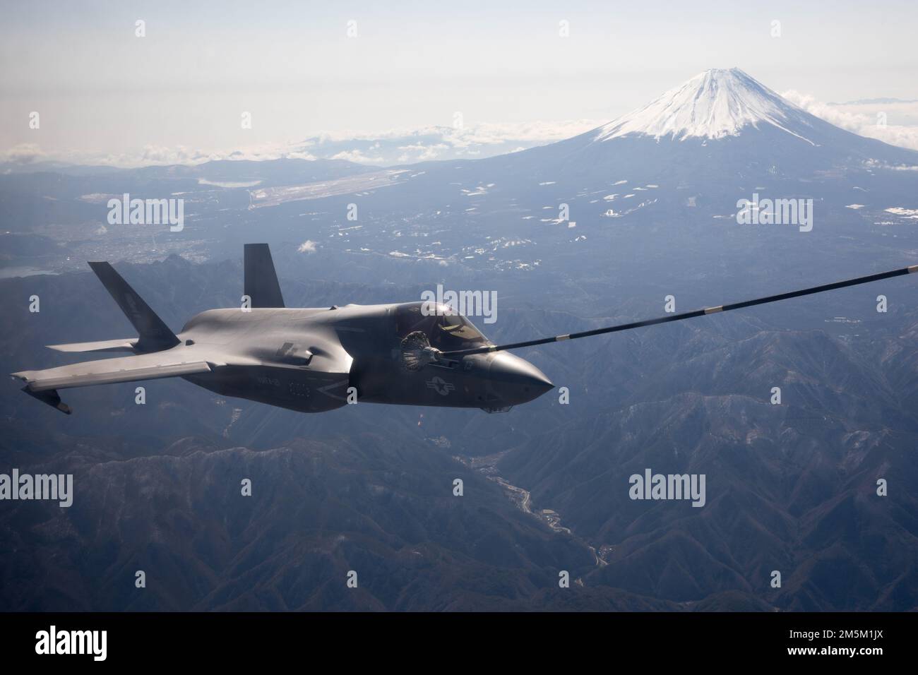 A U.S. Marine Corps F-35B Lightning II with Marine Fighter Attack Squadron (VMFA) 121 conducts aerial refueling with Marine Aerial Refueler Transport Squadron (VMGR) 152 near Mt. Fuji, Japan, March 24, 2022. Marines with VMGR-152 supported Marines with VMFA-121 during a training flight simulating close air support at Camp Fuji, Japan. Marine Corps aviation routinely conducts training throughout the region to remain combat-ready in support of a free and open Indo-Pacific and to demonstrate our commitment to the Treaty of Mutual Cooperation and Security between the U.S. and Japan. Stock Photo