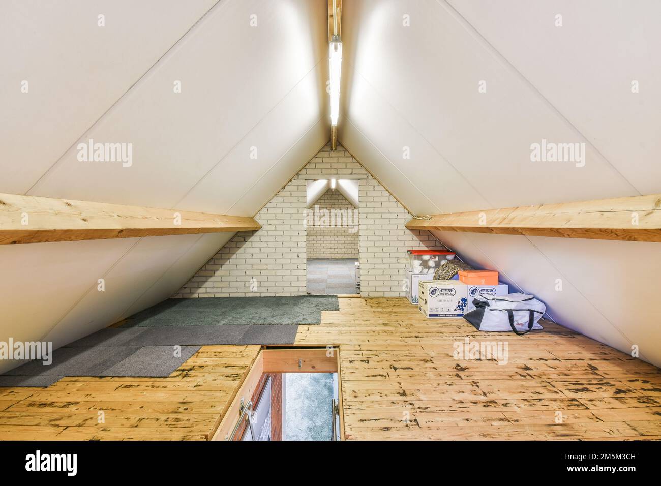 the inside of an attic with wood flooring and white walls, including