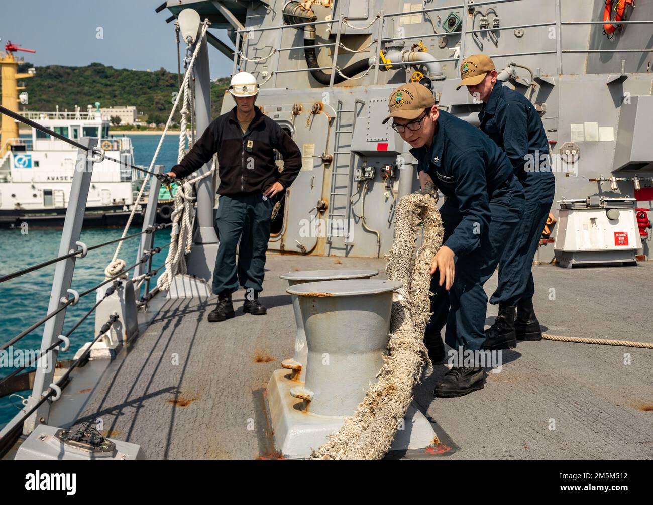 OKINAWA, Japan (March 24, 2022) Sailors aboard Arleigh Burke-class guided-missile destroyer USS Ralph Johnson (DDG 114) heave a line. Ralph Johnson is assigned to Task Force 71/Destroyer Squadron (DESRON) 15, the Navy’s largest forward-deployed DESRON and the U.S. 7th fleet’s principal surface force. Stock Photo