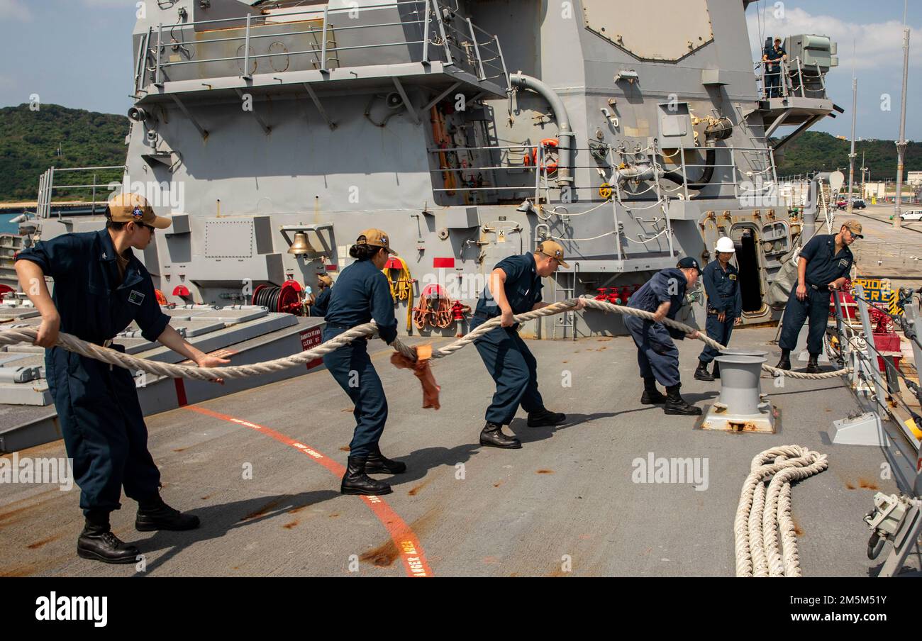 OKINAWA, Japan (March 24, 2022) Sailors aboard Arleigh Burke-class guided-missile destroyer USS Ralph Johnson (DDG 114) heave a line. Ralph Johnson is assigned to Task Force 71/Destroyer Squadron (DESRON) 15, the Navy’s largest forward-deployed DESRON and the U.S. 7th fleet’s principal surface force. Stock Photo