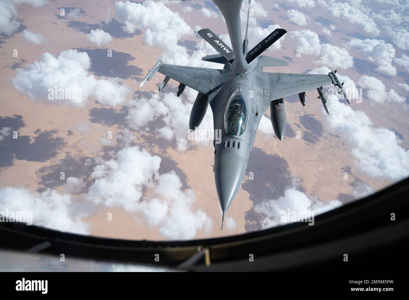 A U.S. Air Force F-16 Fighting Falcon pilot receives fuel from a U.S. Air Force KC-135 Stratotanker over the U.S. Central Command area of responsibility March 24th, 2022. The F-16 Fighting Falcon delivers airpower and showcases Ninth Air Force (Air Forces Central)’s commitment to security and stability in the USCENTCOM AOR. Stock Photo