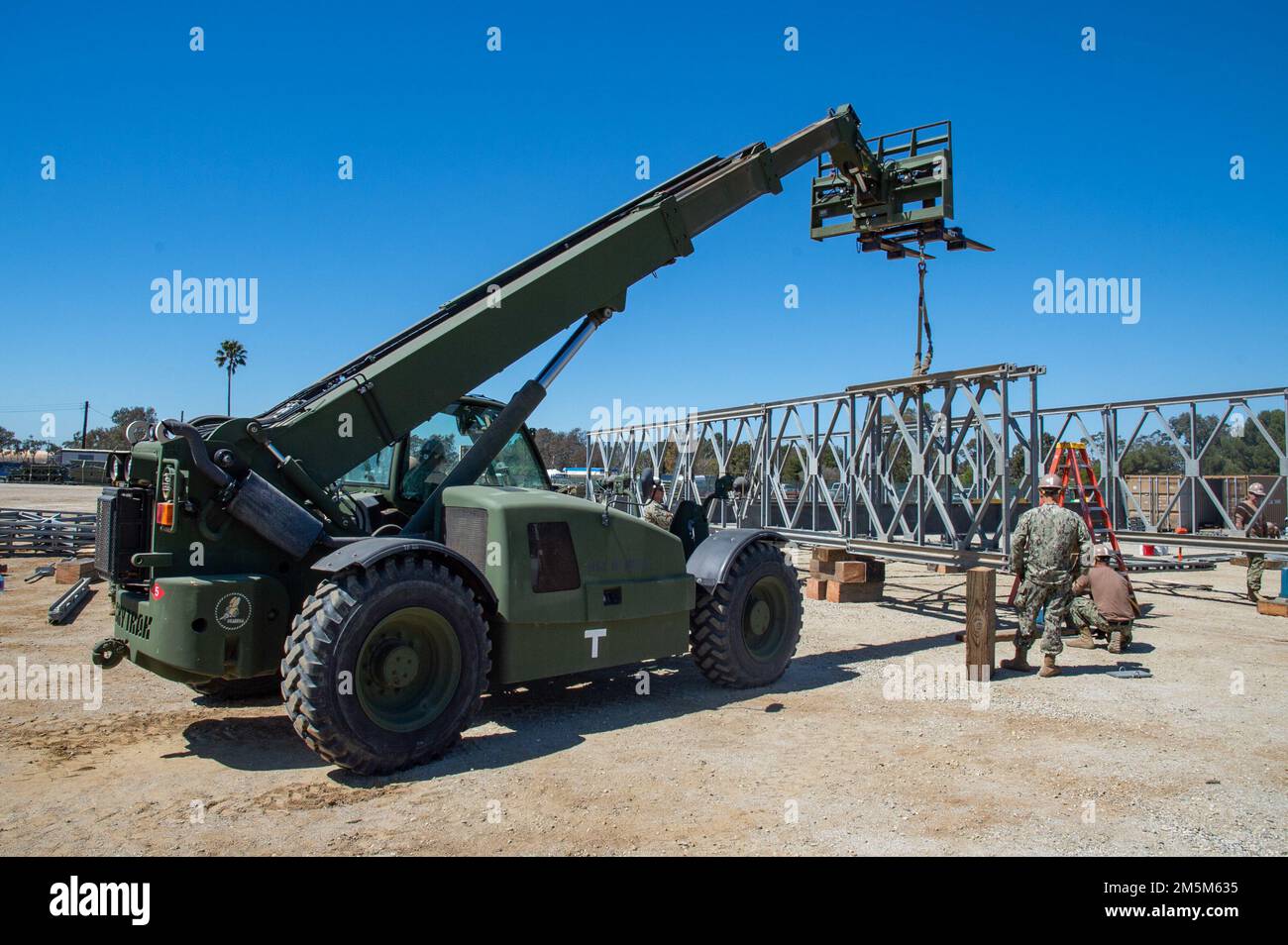 220323-N-MQ841-1025 PORT HUENEME, Calif. (March 23, 2022) U.S. Navy Seabees assigned to Naval Mobile Construction Battalion (NMCB) 5 assemble a Mabey Johnson bridge during the battalion's Command Post Exercise onboard Naval Base Ventura County Port Hueneme, California. The U.S. Navy Seabees with NMCB-5 are homeported out of Port Hueneme. They train on high-quality construction, expeditionary logistics, and combat operations to execute construction and engineering projects for major combat operations, disaster response, and humanitarian assistance. Stock Photo