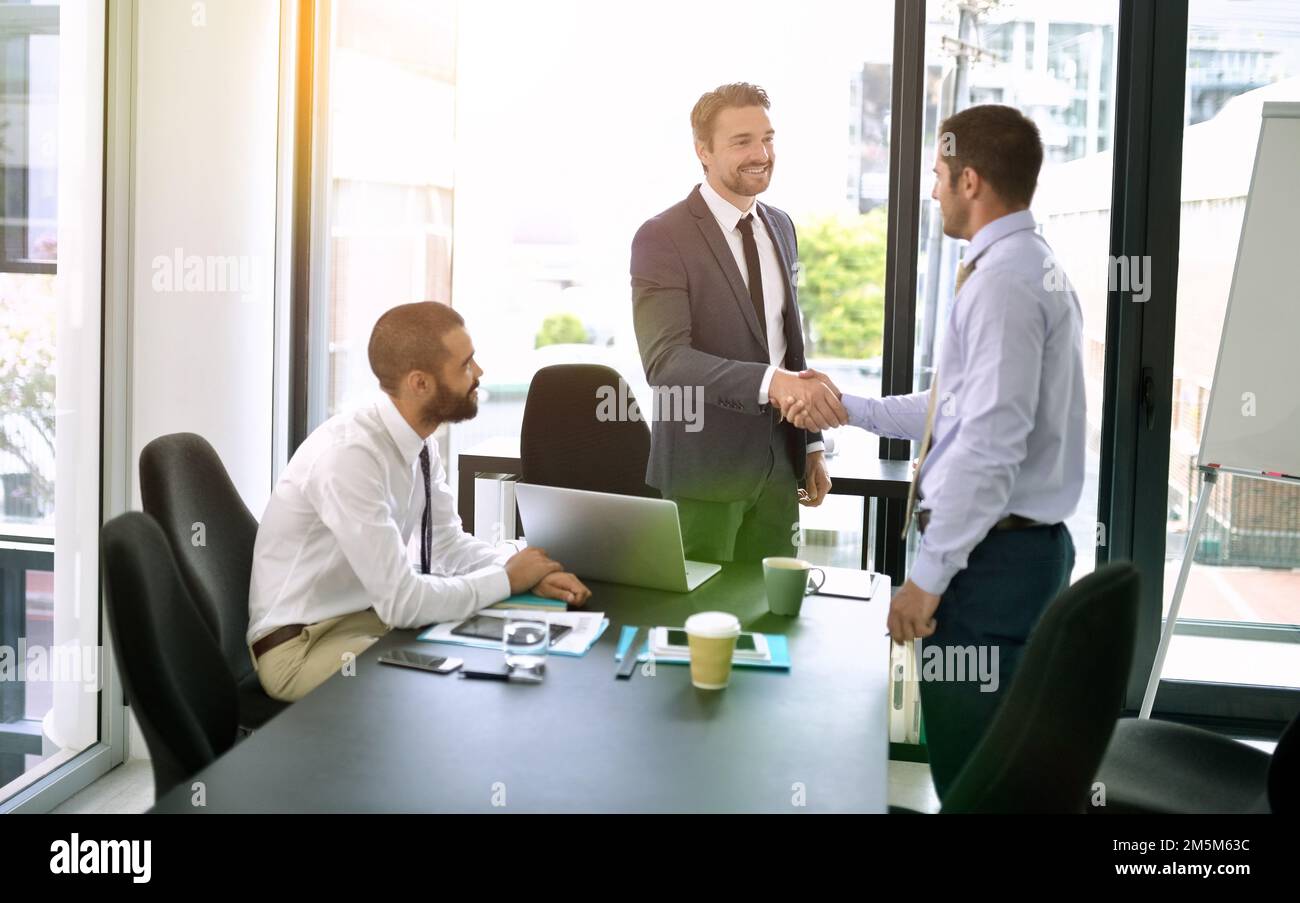 The beginning of a great business relationship. colleagues shaking hands during a formal meeting in an office. Stock Photo