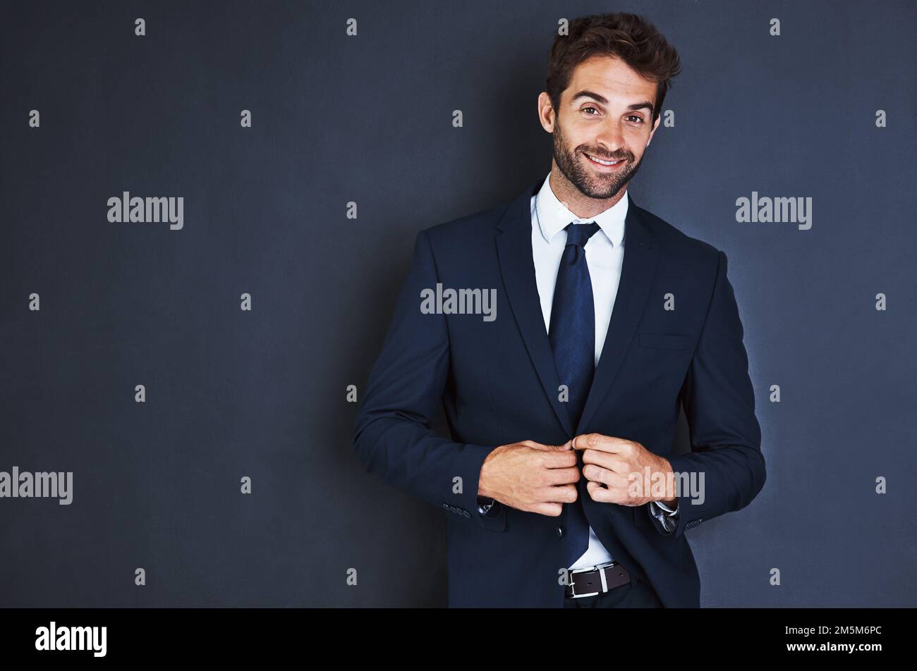 Move forward with confidence. Studio portrait of a handsome young businessman standing against a grey background. Stock Photo