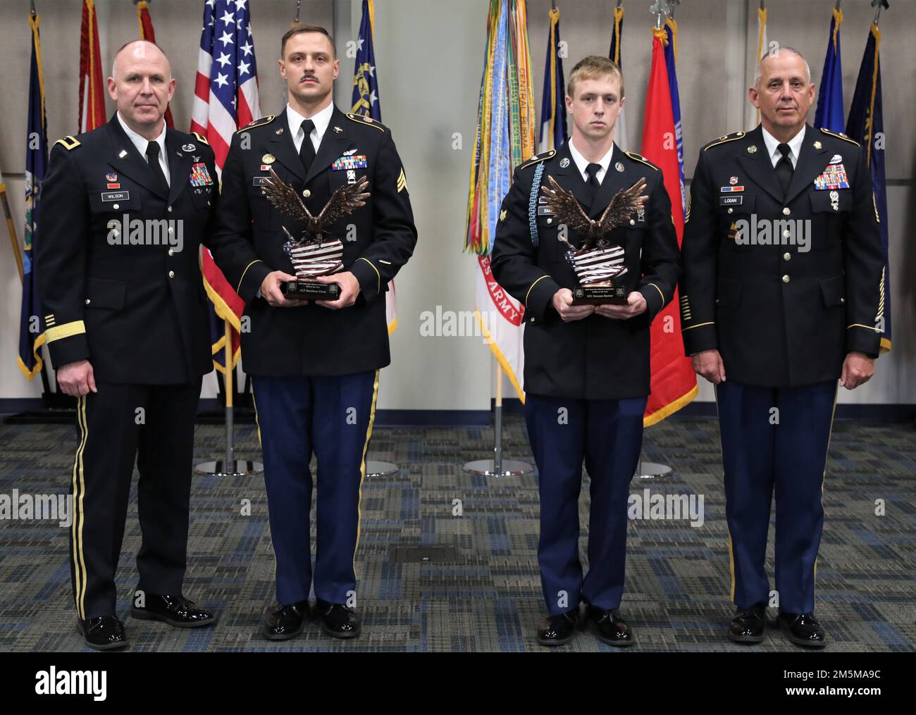 U.S. Army Brig. Gen. Dwayne Wilson (far left), commanding general of the Georgia Army National Guard, and Command Sgt. Maj. Jeff Logan (far right), state command sergeant major of the Georgia Army National Guard, present trophies to Sgt. Matthew Fiore (center left) and Spc. Keenan Baxter (center right) March 25, 2022, at Clay National Guard Center in Marietta, Georgia. Fiore won the 2022 Georgia Army National Guard State Best Noncommissioned Officer and Baxter won the title of State Best Warrior. Stock Photo