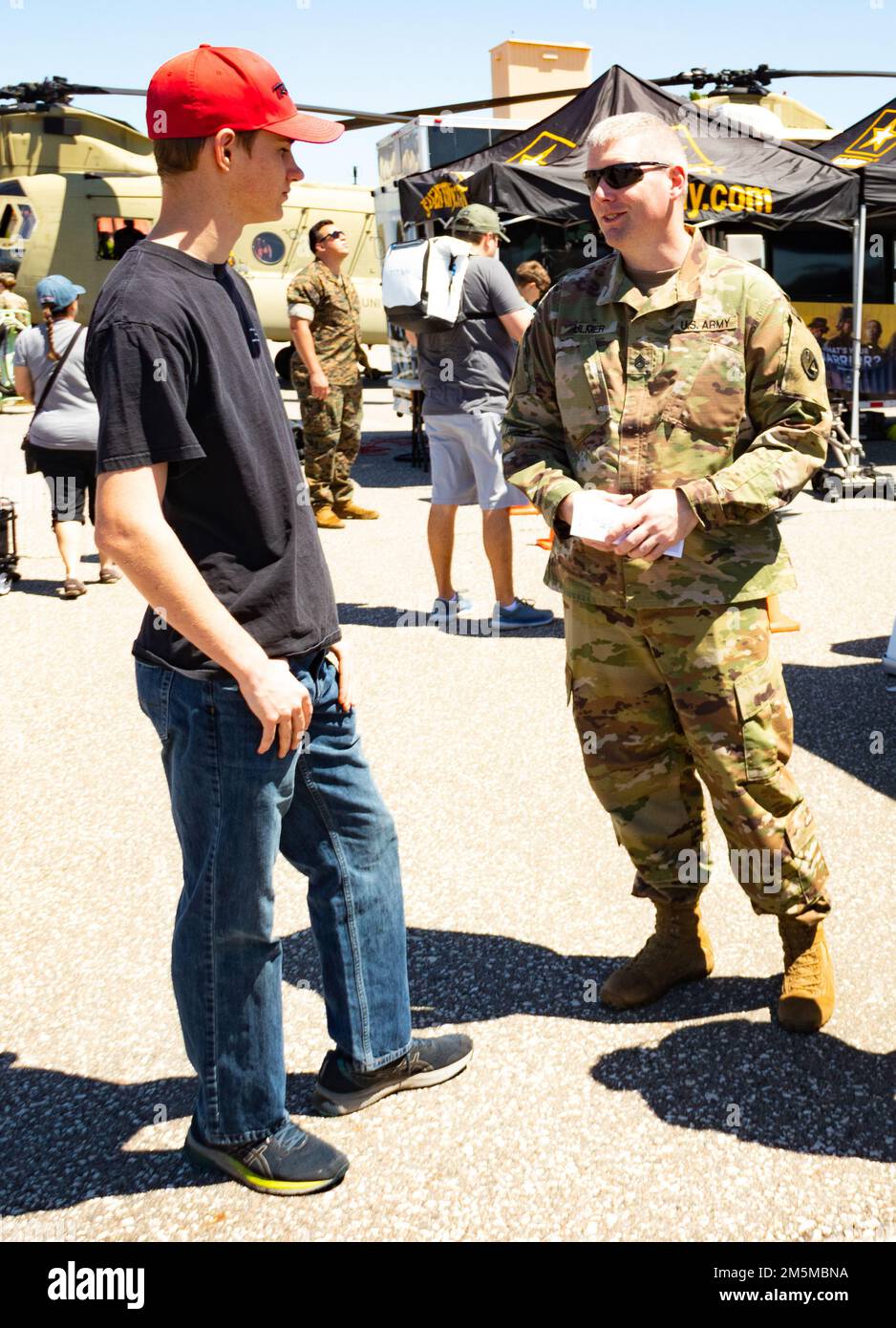U.S. Army Staff Sgt. Bradley S. Ulmer, an instructor assigned to 8th Battalion, 5th Brigade, 94th Training Division, 80th Training Command, speaks with a young adult about the benefits of serving in the U.S. Army during the Tampa Bay Airfest in MacDill Air Force Base March 25, 2022. Ulmer, an Army Reserve Soldier hailing from Cookeville, Tennessee, was one of dozens of Soldiers who helped set up and operate the Airfest’s Army Village that featured a myriad of modern and historical Army vehicles, helicopters and airborne equipment. The static and interactive displays attracted thousands of visi Stock Photo