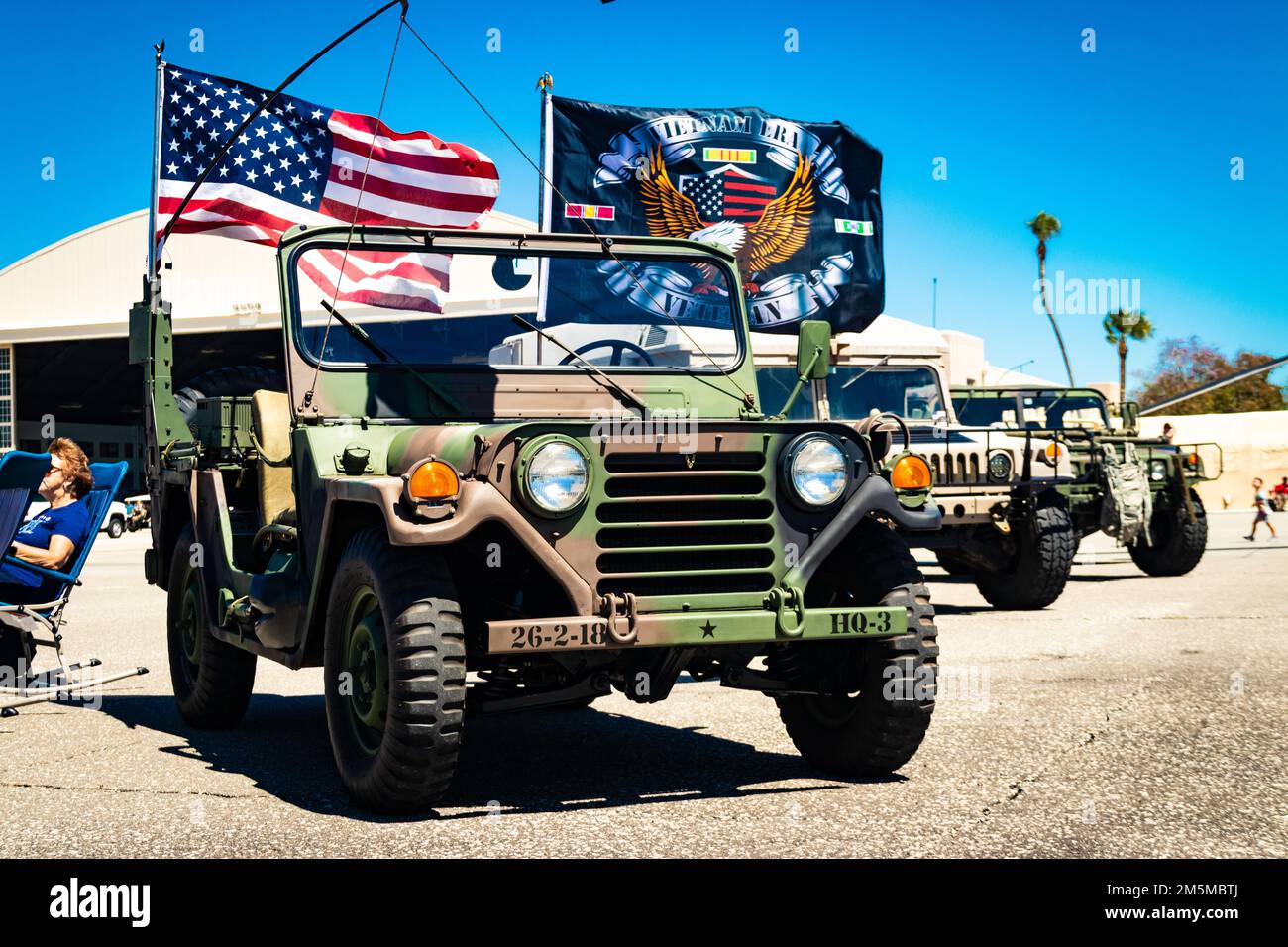 Flags flutter atop a World War II era jeep that resides next to a pair of Humvees – the jeep’s successor – during the Tampa Bay Airfest held March 25, 2022, at MacDill Air Force Base, Florida. The First Florida Chapter of the Military Vehicle Preservation Association displayed the jeep, Humvees and other U.S. Army historical vehicles and equipment at the Airfest’s Army Village. The Army Village’s static displays and interactive exhibits attracted thousands of visitors to the Army Village, where dozens of Soldiers from various branches, components and Military Occupation Specialties share their Stock Photo