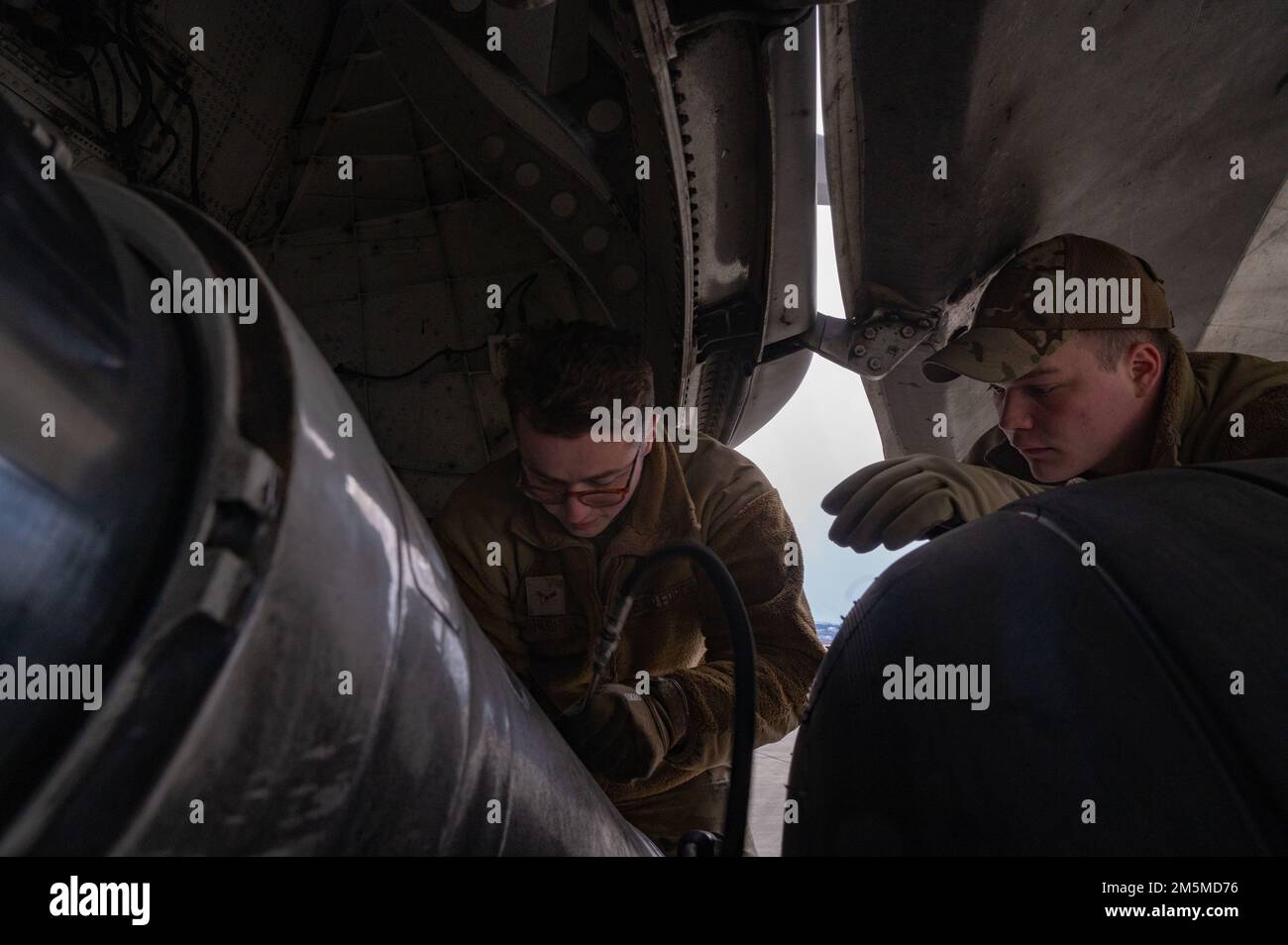 U.S. Air Force Airman 1st Class Brigham Cheshire, left, and Senior Airman Jake Morley, both crew chiefs assigned to the 62nd Maintenance Squadron, replace a brake on a C-17 Globemaster III during Exercise Rainier War 22A at Joint Base Elmendorf-Richardson, Alaska, March 25, 2022. The exercise is designed to demonstrate the wing’s ability to operate and survive while defeating challenges to the U.S. military advantage in all operating domains – air, land, sea and cyberspace. Stock Photo