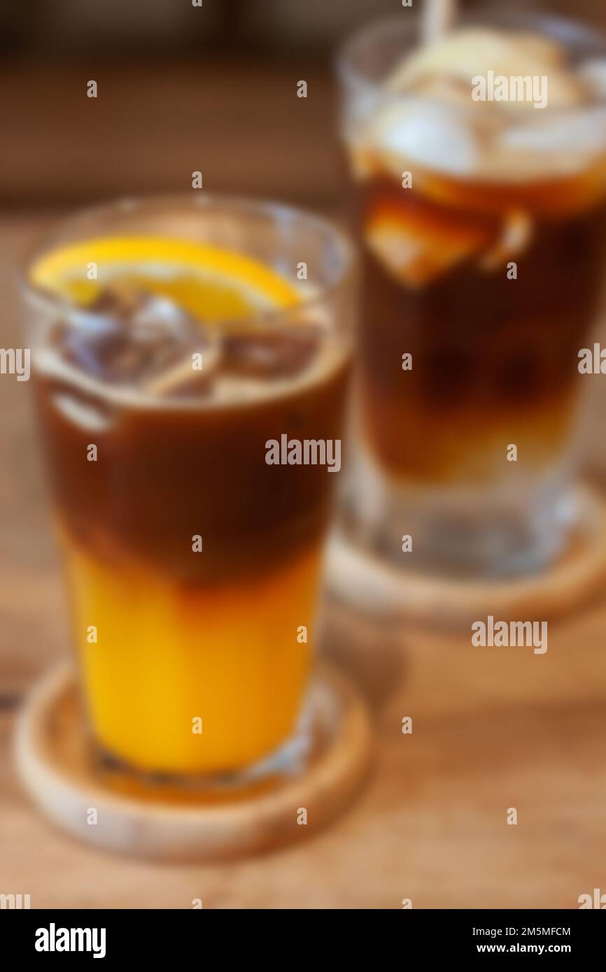 Glass of americano mixed with orange juice blur background, stock photo Stock Photo