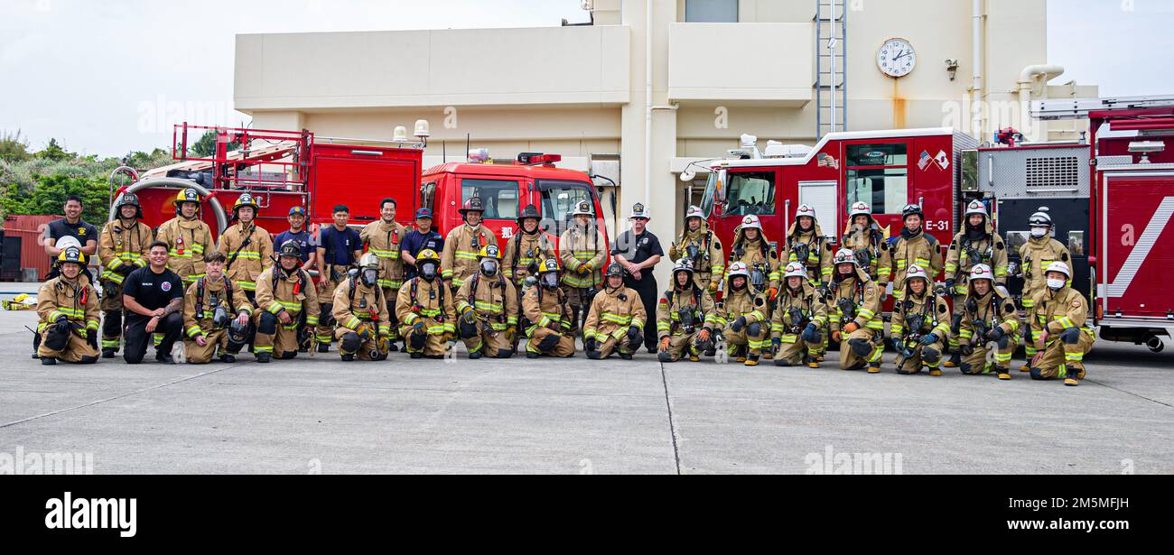 Firefighters with Marine Corps Installations Pacific Fire and Emergency Services pose with firefighters from the Naha City Fire Department for a group photo on Camp Hansen, Okinawa, Japan, March 25, 2022. MCIPAC F&ES and the Naha City Fire Department assembled and conducted live-fire training to compare the different firefighting techniques and methods each department uses to accomplish the same mission. Stock Photo