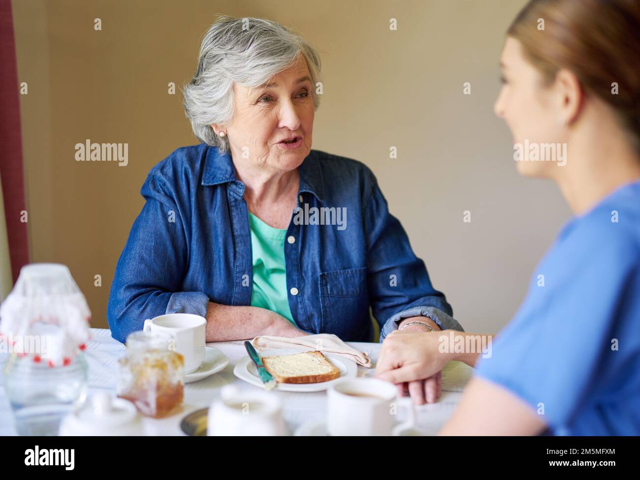 Shes got many stories to share. a resident and a nurse at a retirement home. Stock Photo