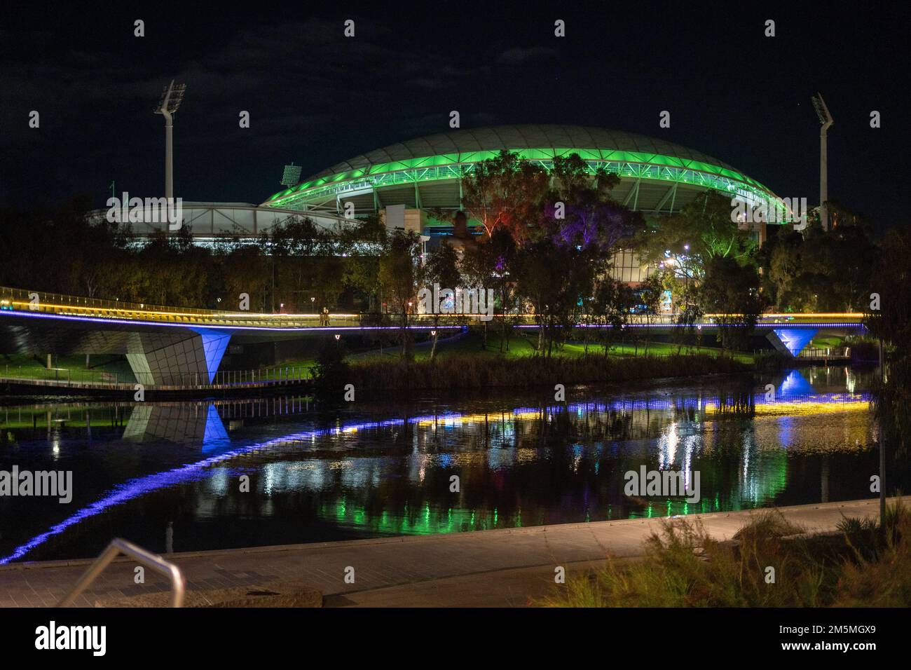 A night view of The Riverbank Precinct Pedestrian Bridge and oval football stadium in Adelaide Stock Photo